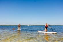 Girls paddle boarding at Radical Rides on Pensacola Beach